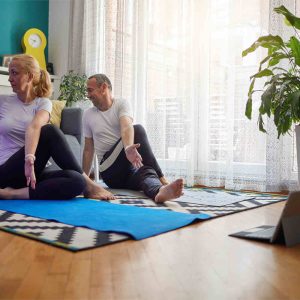 Couple practicing yoga at home with online classes.